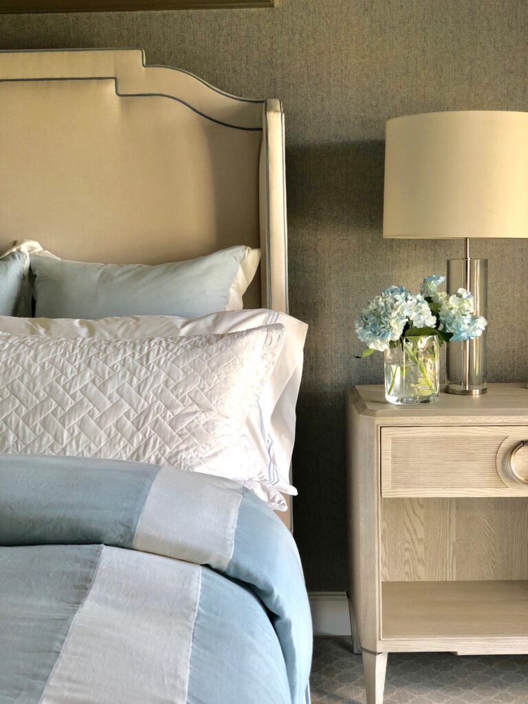 Tan and light blue bedroom with wood nightstand
