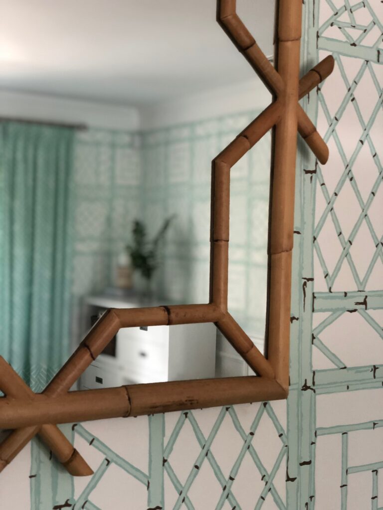 bamboo finished mirror against teal wallpaper