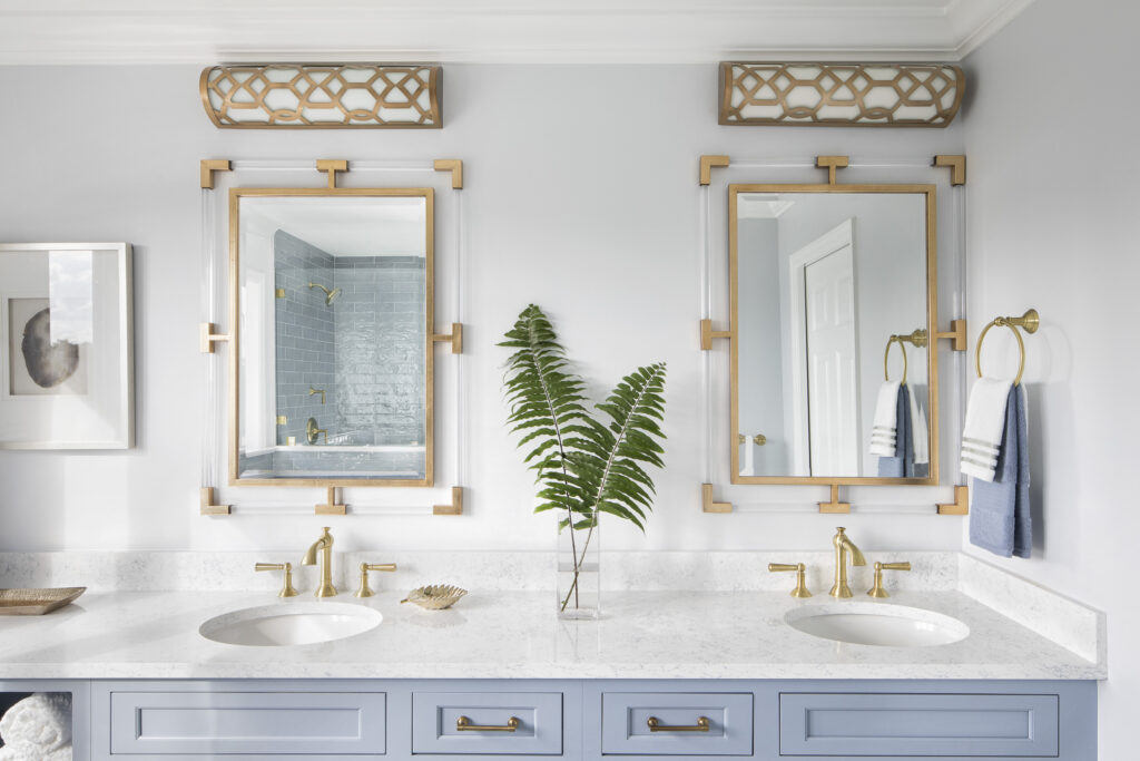 double blue vanity with brass mirrors and brass light fixtures