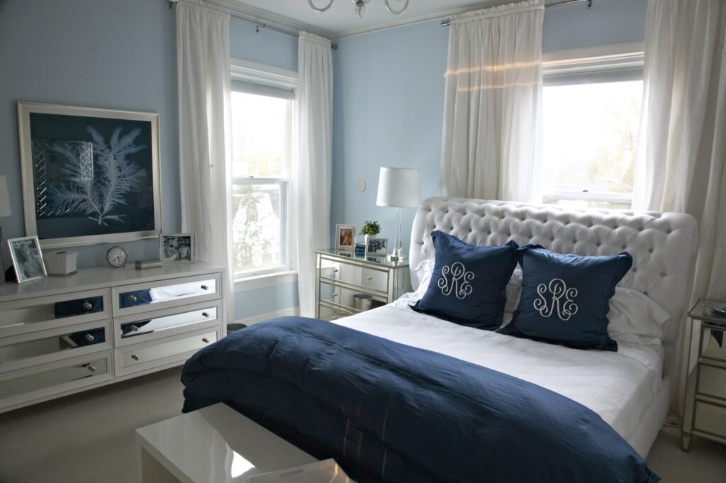 Light blue bedroom with mirrored dresser and nightstands
