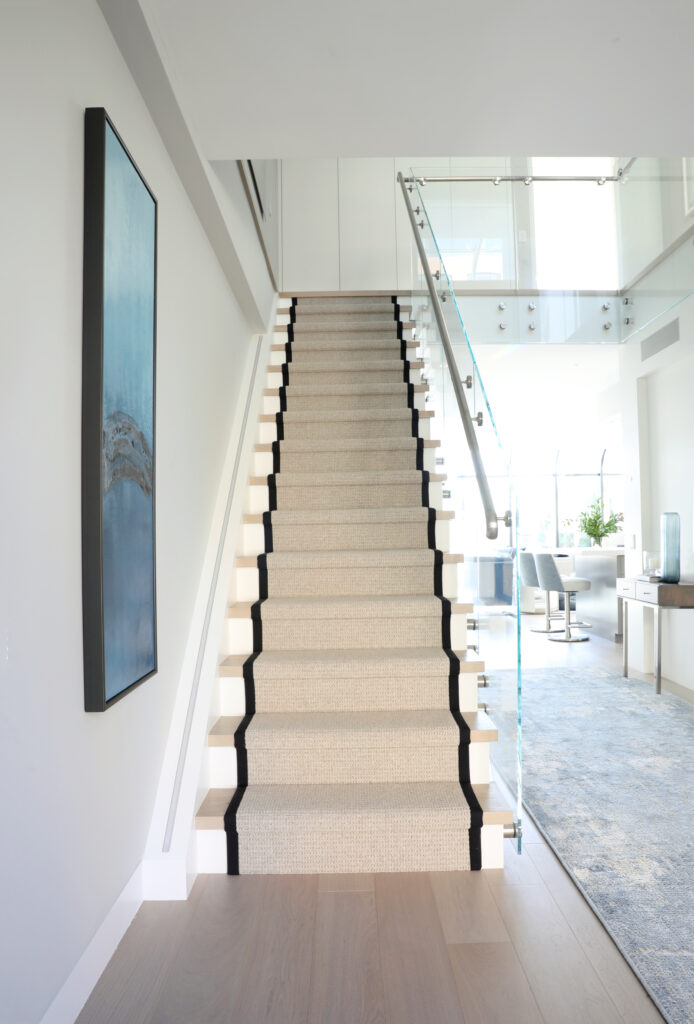 Light wood stairs with tan and black runner